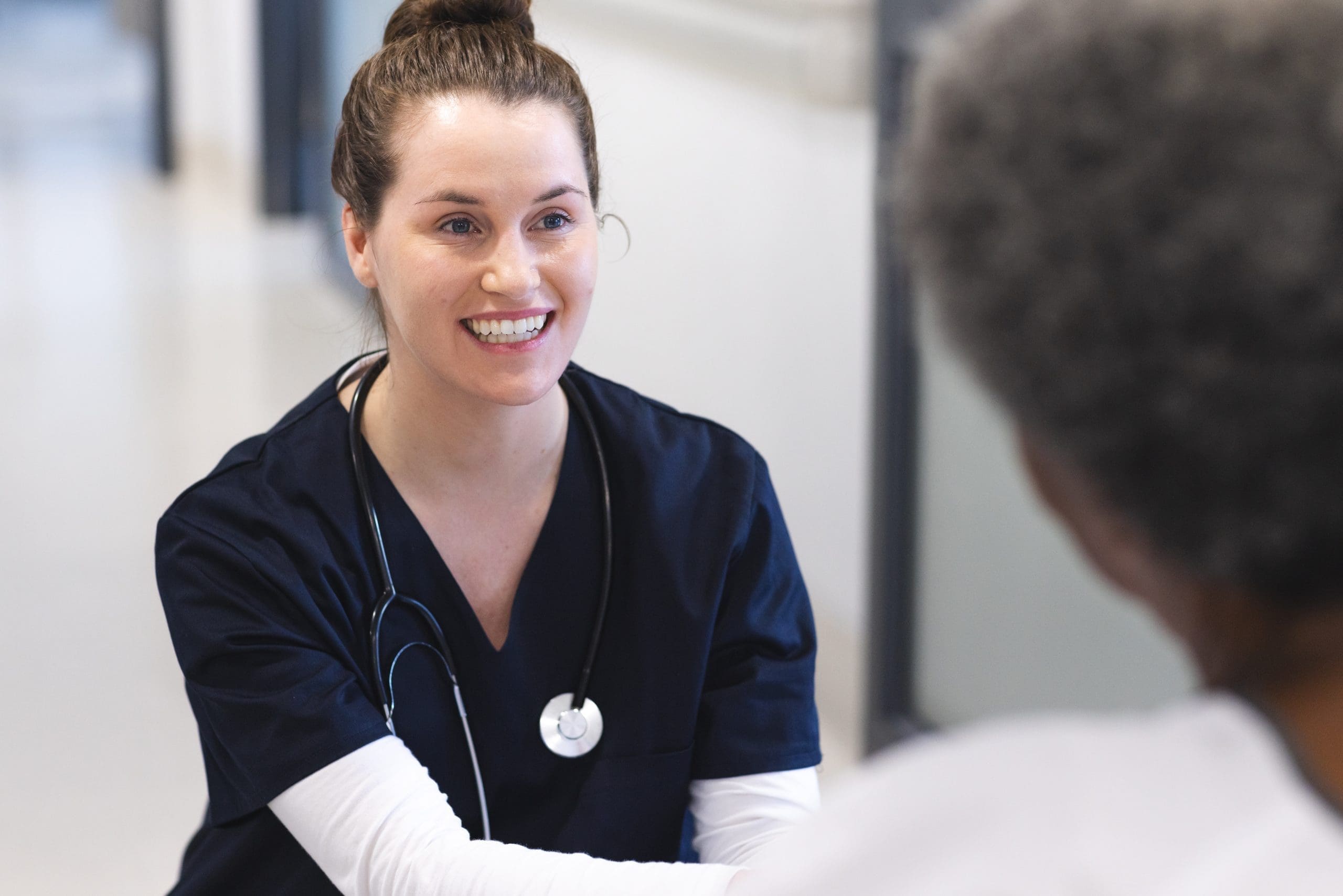 Happy diverse female doctor talking with senior female patient in wheelchair in hospital corridor. Medicine, healthcare and medical services, unaltered. happy diverse female doctor talking with senior fe 2023 11 27 05 18 01 utc scaled
