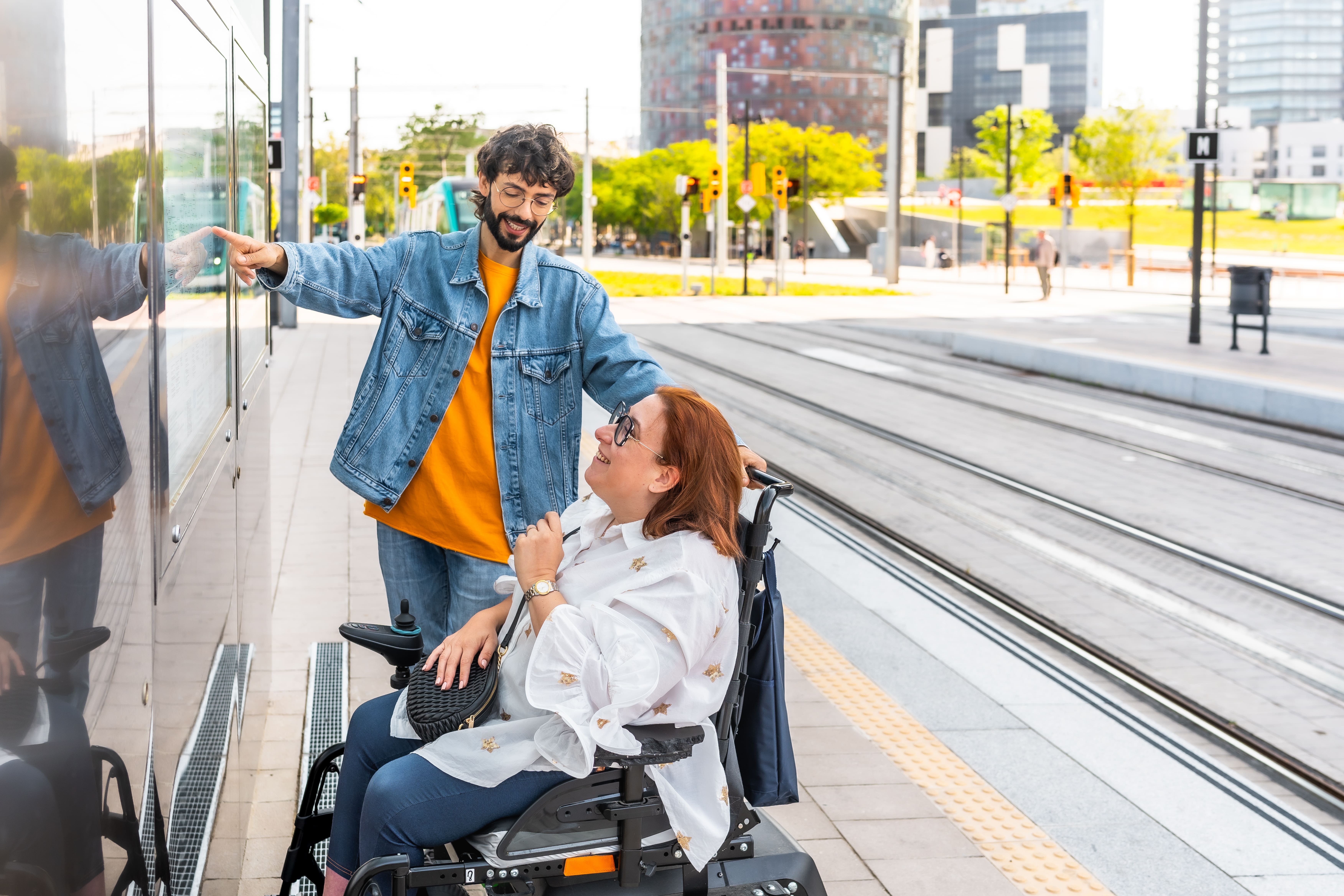 man showing tram schedule to woman on wheelchair a 2025 06 29 17 32 02 utc
